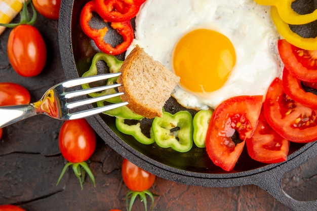 Free photo top view tasty omelette with tomatoes and sliced bell-peppers on dark table