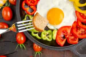 Free photo top view tasty omelette with tomatoes and sliced bell-peppers on dark table