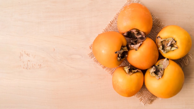 Free Photo top view tasty persimmons with copy space