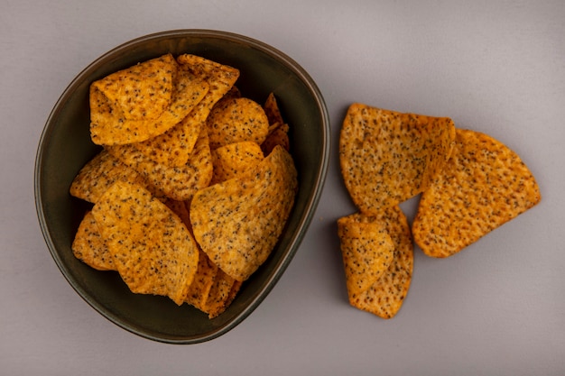 Top view of tasty potato chips on a bowl with chips isolated