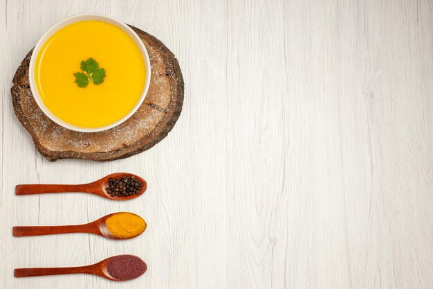 Top view of tasty pumpkin soup with pepper on white