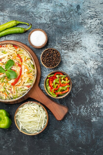 Top view of tasty salad with fresh vegetables on dark surface