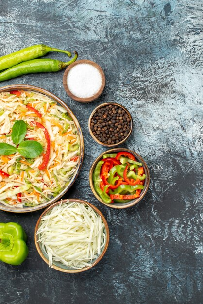 Top view of tasty salad with fresh vegetables on dark surface