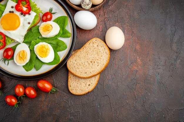 Top view tasty sandwich with cooked eggs and tomatoes on dark table