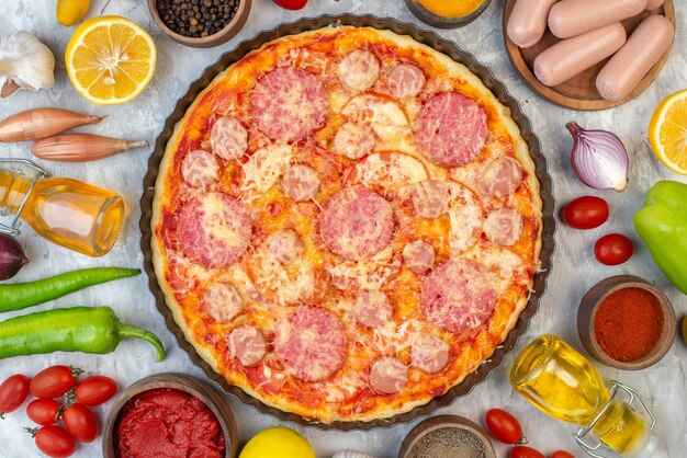 Top view tasty sausage pizza with fresh vegetables on a white table oven color dough pie cake bake pizza italy fast-food