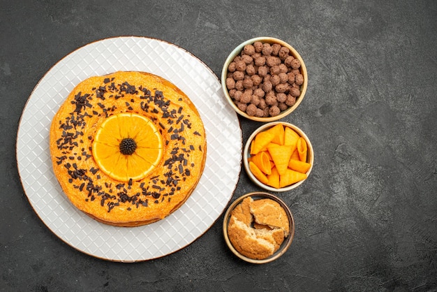 Top view tasty sweet pie with orange slices on dark surface pie cake dessert tea sweet biscuit