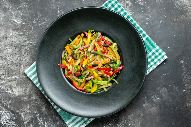 Top view of tasty vegetable salad on dark surface