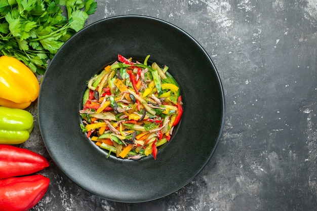 Top view of tasty vegetable salad on dark surface