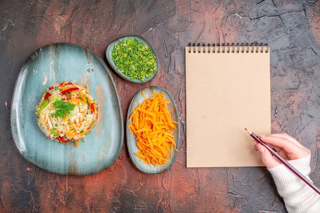 Free photo top view tasty vegetable salad inside plate with greens and carrot on dark table