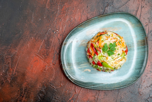 Top view tasty vegetable salad round shaped inside plate on the dark table