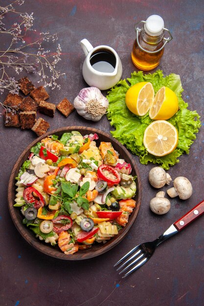 Top view of tasty vegetable salad with fresh lemon slices on dark