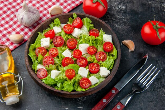 Top view tasty vegetable salad with sliced cheese tomatoes and seasonings on a dark background color food meal diet lunch health