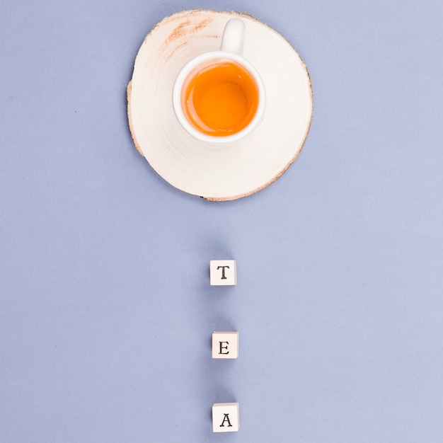 Free Photo top view tea cup with letter dices