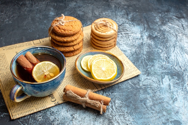 Top view of tea time with stacked delicious cookies cinnamon lemon on an old newspaper