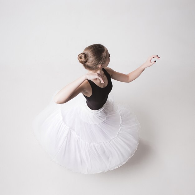 The top view of the teen ballerina on white studio background