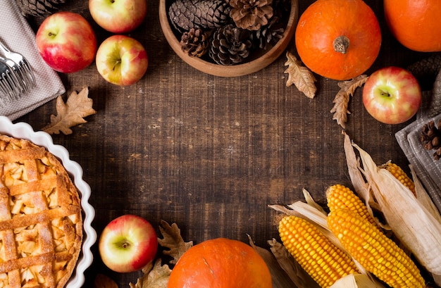 Top view of thanksgiving apple pie with corn and pine cones