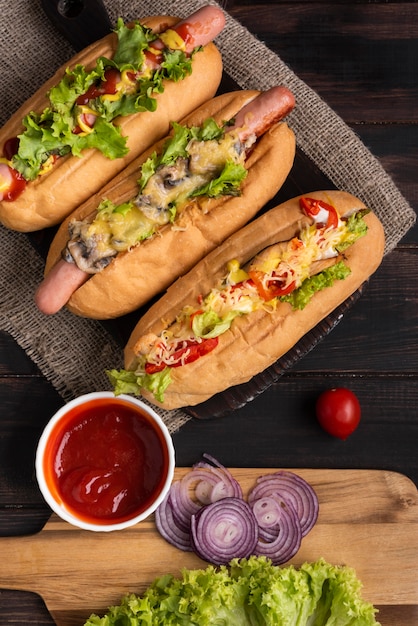 Top view of three hot dogs with ketchup and onions