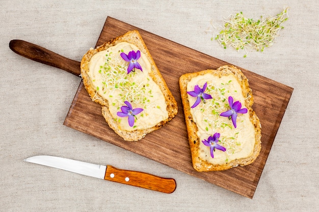 Top view of toast with flowers on chopping board