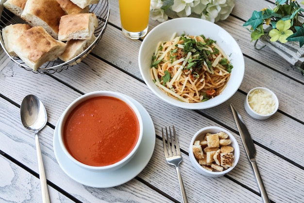 Top view tomato soup with cheese bread crumbs and bread on the table