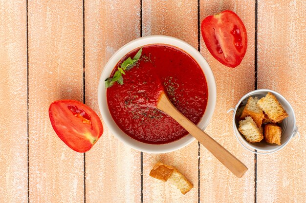 Free Photo top view tomato soup with greens along with red tomatoes on rustic table, soup food meal dinner vegetable