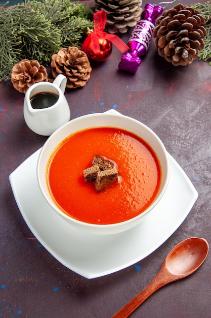 Top view of tomato soup with sliced bread inside on black