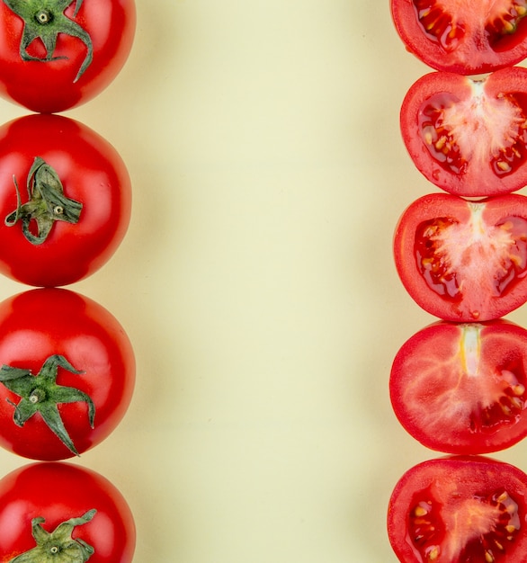 Free photo top view of tomatoes on left and right sides on yellow surface with copy space