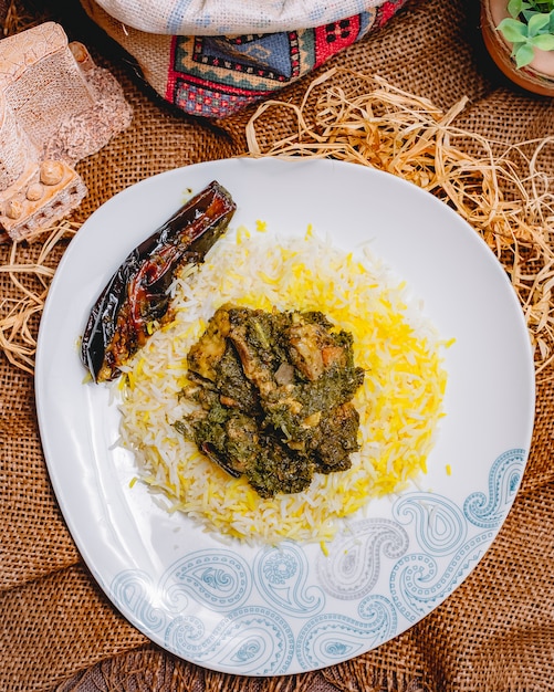 Top view traditional azerbaijani pilaf syabzi fried meat with greens and rice with eggplant