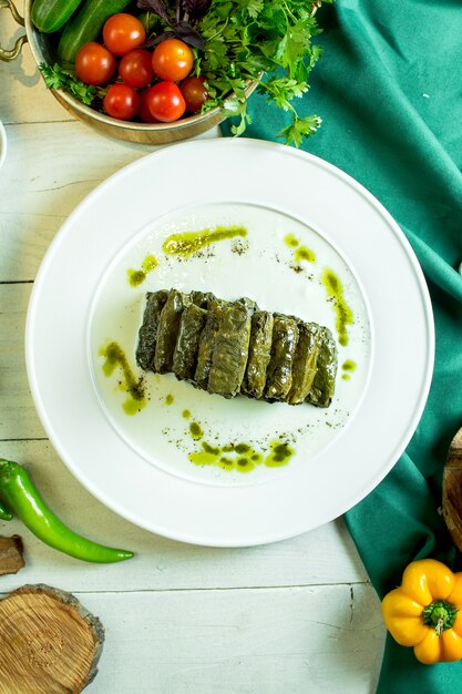 Top view of traditional caucasian cuisine dolma with grape leaves on a plate