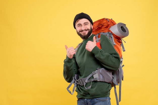 Top view of travel concept with smiling happy young guy with packpack and making ok gesture