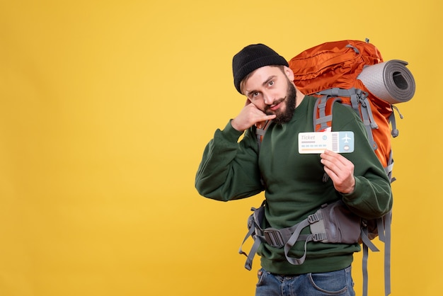 Free photo top view of travel concept with young guy with packpack and making call me gesture