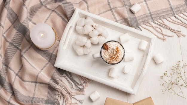 Top view of tray with coffee with whipped cream and candle