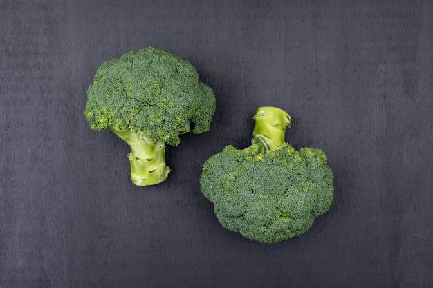 Top view two bunches of broccoli on black surface