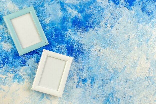 Top view two empty photo frames on blue white grunge with free space