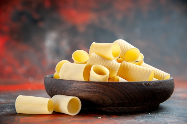 Free photo top view of uncooked pastas inside and outside of the pot on black background