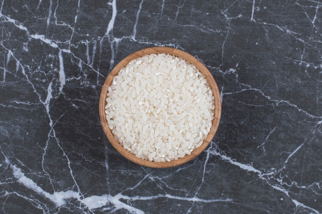 Free Photo top view. uncooked rice in wooden bowl.