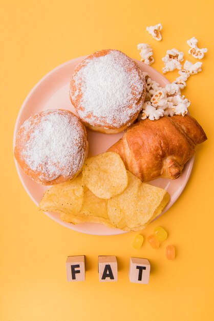 Top view unhealthy snacks with fat letters