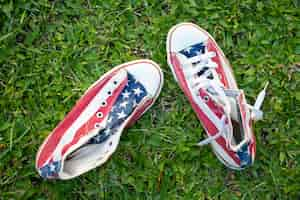 Free photo top view usa flag sneakers on grass