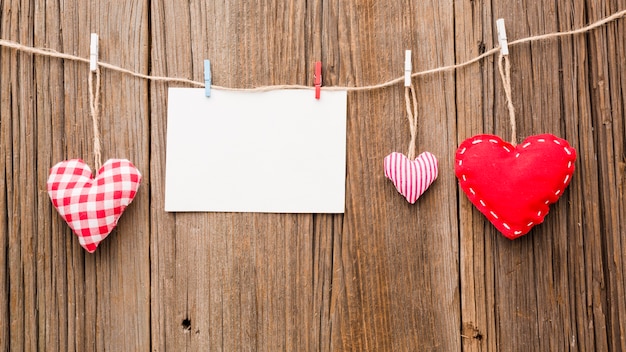 Top view of valentines day ornaments on string with paper