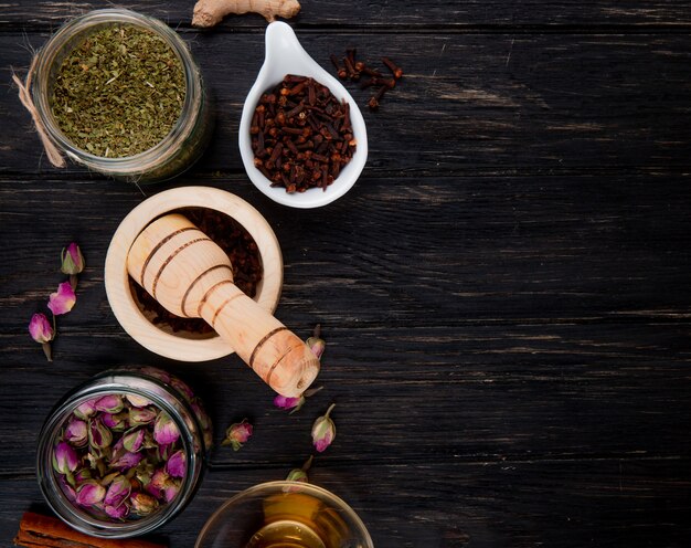 Top view of various spices and herbs on black wood with copy space