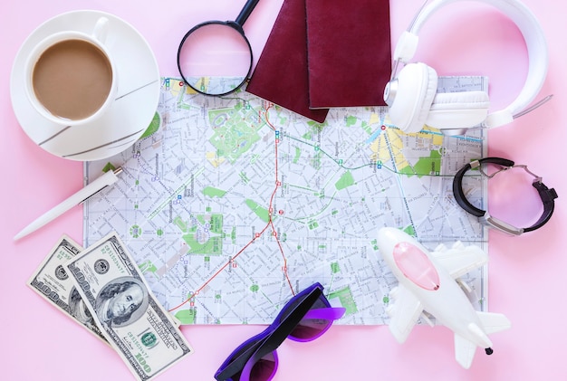 Free photo top view of various traveler accessories and cup of tea on pink background