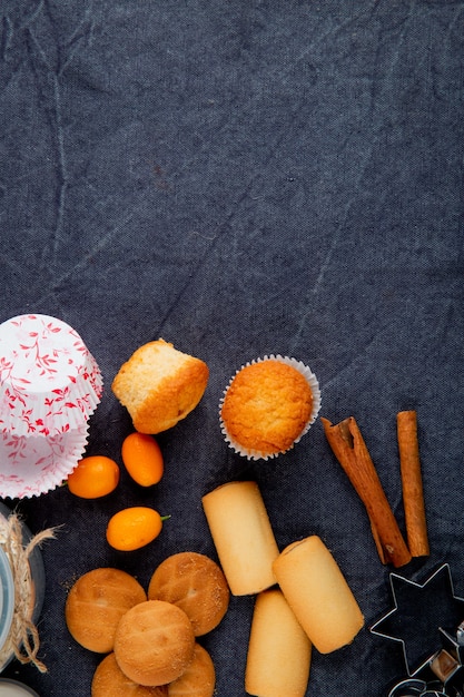 Free photo top view of various types of sweet cookies and muffins on grey background with copy space