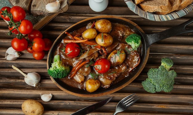 Top view vegetable beef stew in a pottery pan.