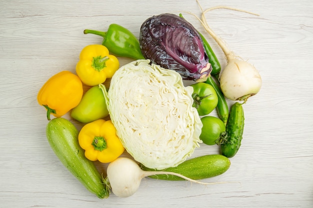 Free photo top view vegetable composition cabbage bell-peppers and radish on white background