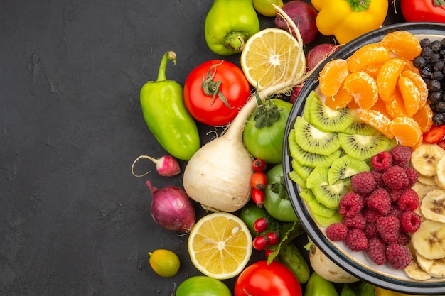 Top view vegetable composition fresh vegetables with sliced fruits on a dark background  life plant ripe diet food salad color