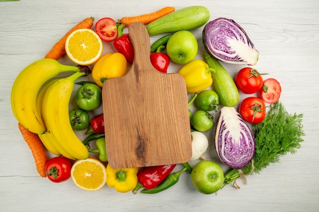 Free photo top view vegetable composition tomatoes cabbage bell-peppers with bananas on white background