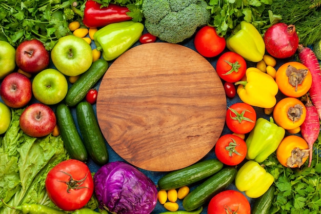 Top view vegetable composition with fresh fruits on blue table color ripe diet salad healthy life