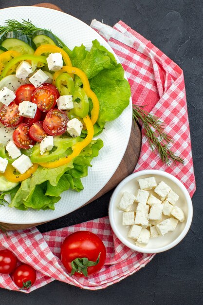 top view vegetable salad consists of sliced tomatoes cucumbers pepper and cheese on dark background