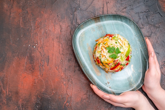 Top view vegetable salad round shaped inside plate on dark table