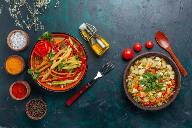 Top view vegetable soup with different seasonings and spicy salad on dark-blue background