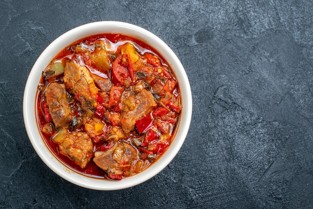 Free photo top view vegetable soup with meat inside plate on a grey